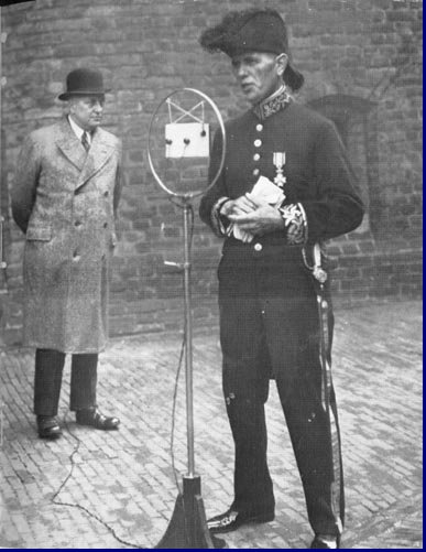 Prinsjesdag 1933. Het liberale kamerlid Bierema in ambtskleding spreekt voor de microfoon. Willem Vogt kijkt toe.