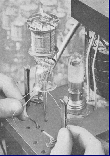 Het testen van de verschillende electroden op kortsluiting voor het samensmelten van de kolf en het binnenwerk. Foto 1939.